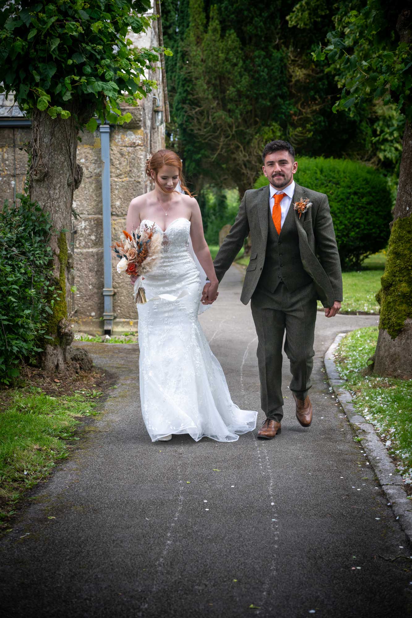 Bride and groom walking down church path in Cornwall - emotional moment captured